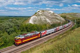 A train curving through misty hills at sunrise